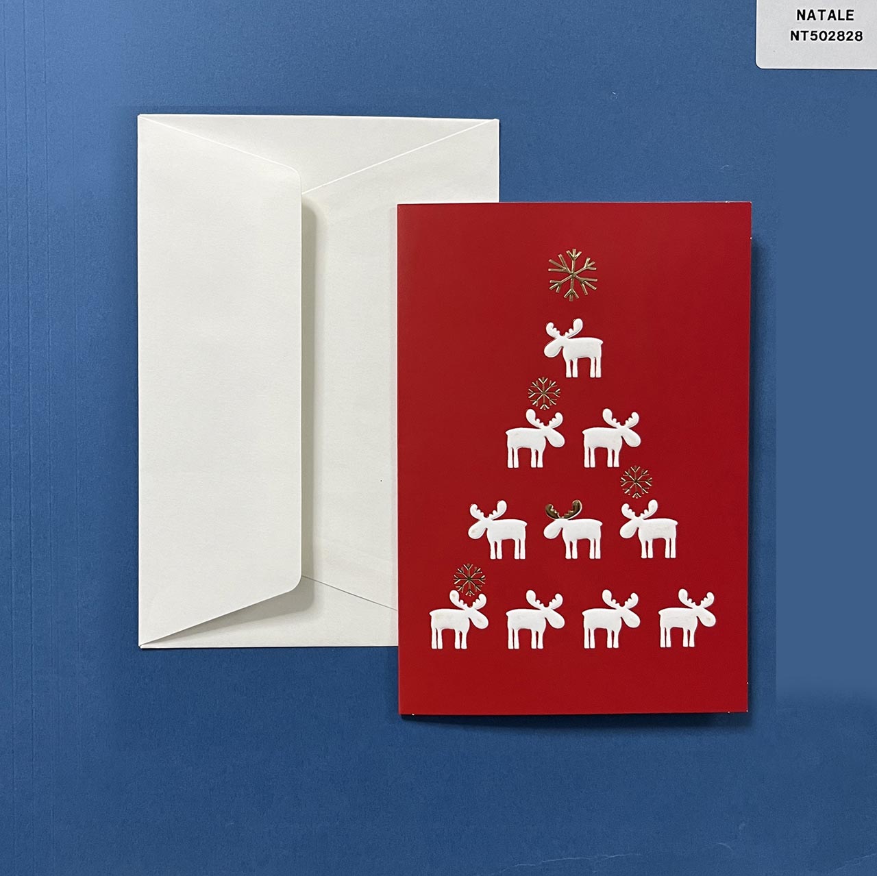 Biglietto di auguri di Natale a libretto verticale cm 11x17,5 personalizzabile nella pagina interna. La copertina con sfondo rosso, presenta renne e fiocchi di neve a rilievo. 